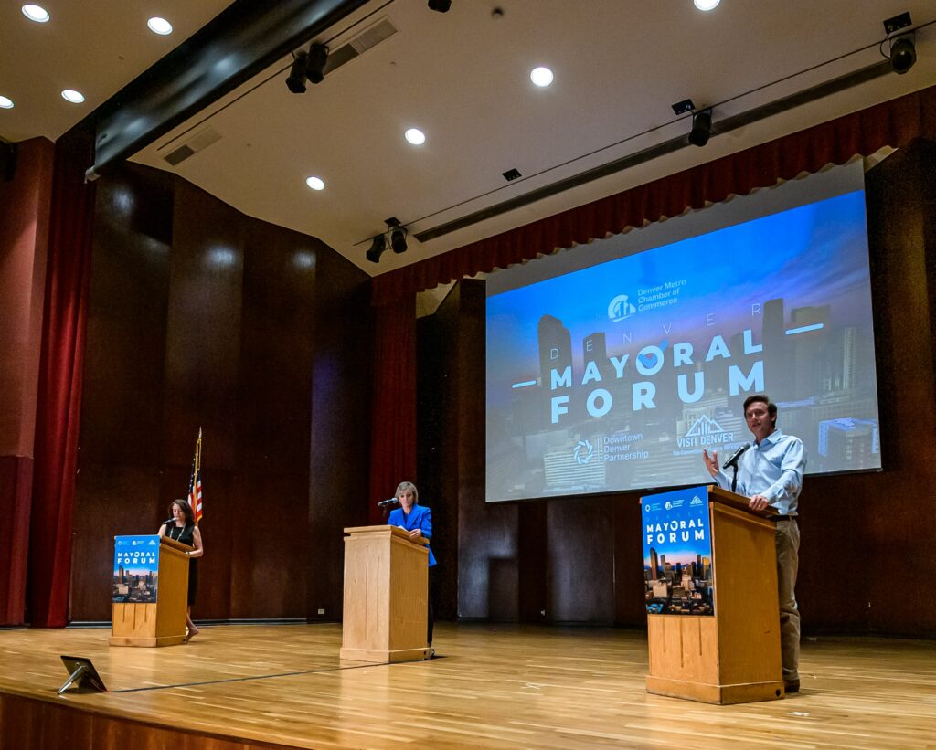 Candidates Kelly Brough and Mike Johnston stand on stage with Shaun Boyd