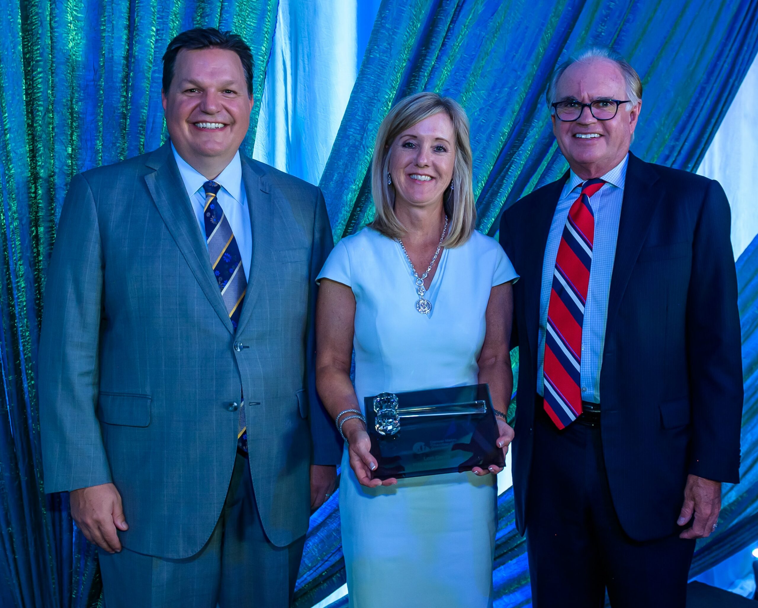 Chamber President & CEO, J. J. Ament; Incoming Chamber Board Chair, Lori Davis, holding the gavel; and outgoing Chamber Board Chair, George Sparks