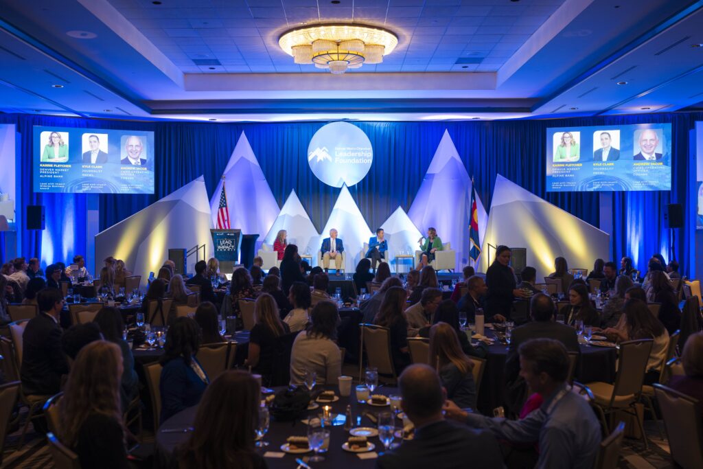 Panelists sit on stage while audience watches