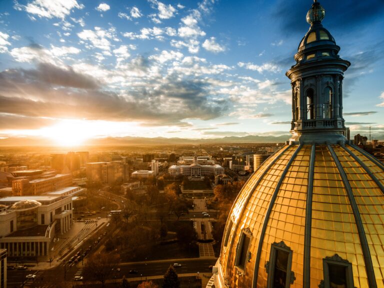 The dome of Colorado State Capitol against cityscape and sunset